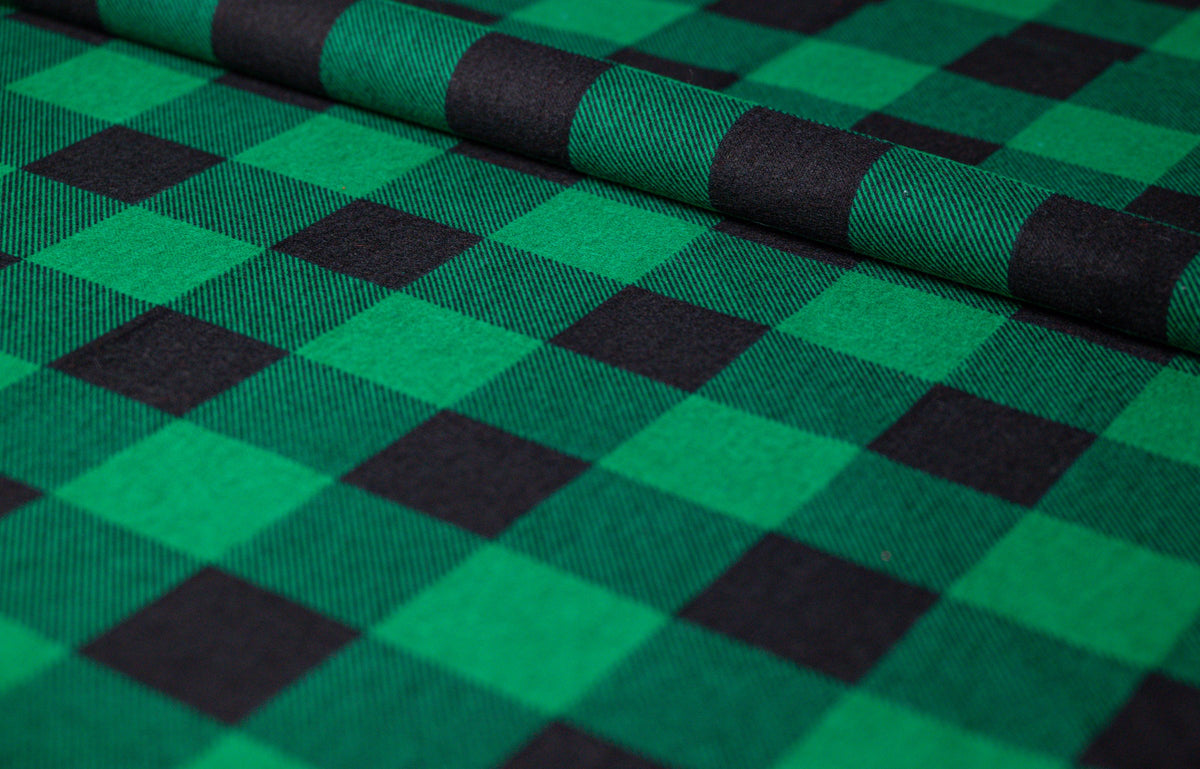 Couverture thérapeutique avec housse en flanelle à carreaux verts : tissu en flanelle enroulé à carreaux vert et noir avec armure sergé visible, détail du tissu photographié de biais